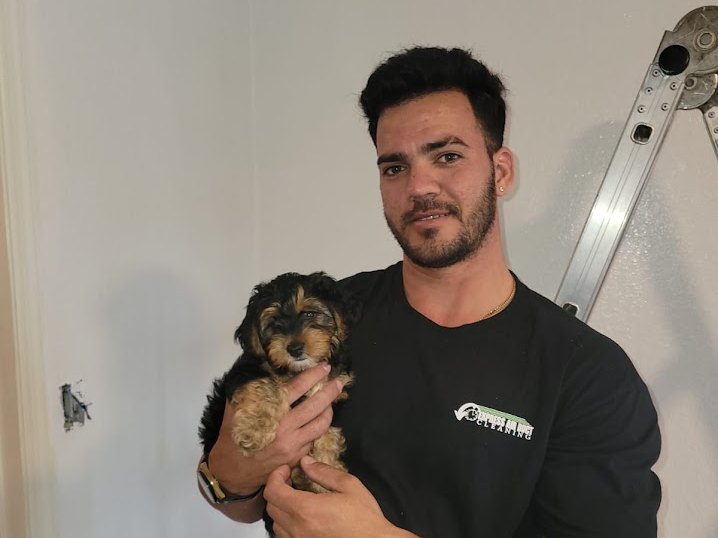 Express Air Duct Cleaning technician in a company shirt holding a puppy